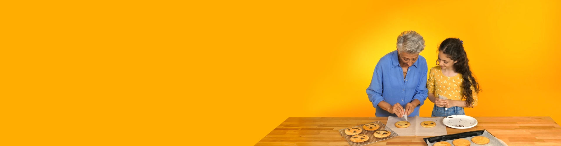 奶奶戴着飞利浦HearLink与孙女一起烘焙饼干